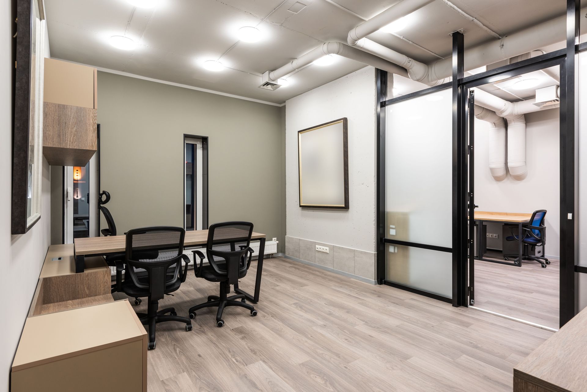 Stylish interior of spacious office with black chairs and wooden tables designed in minimal style